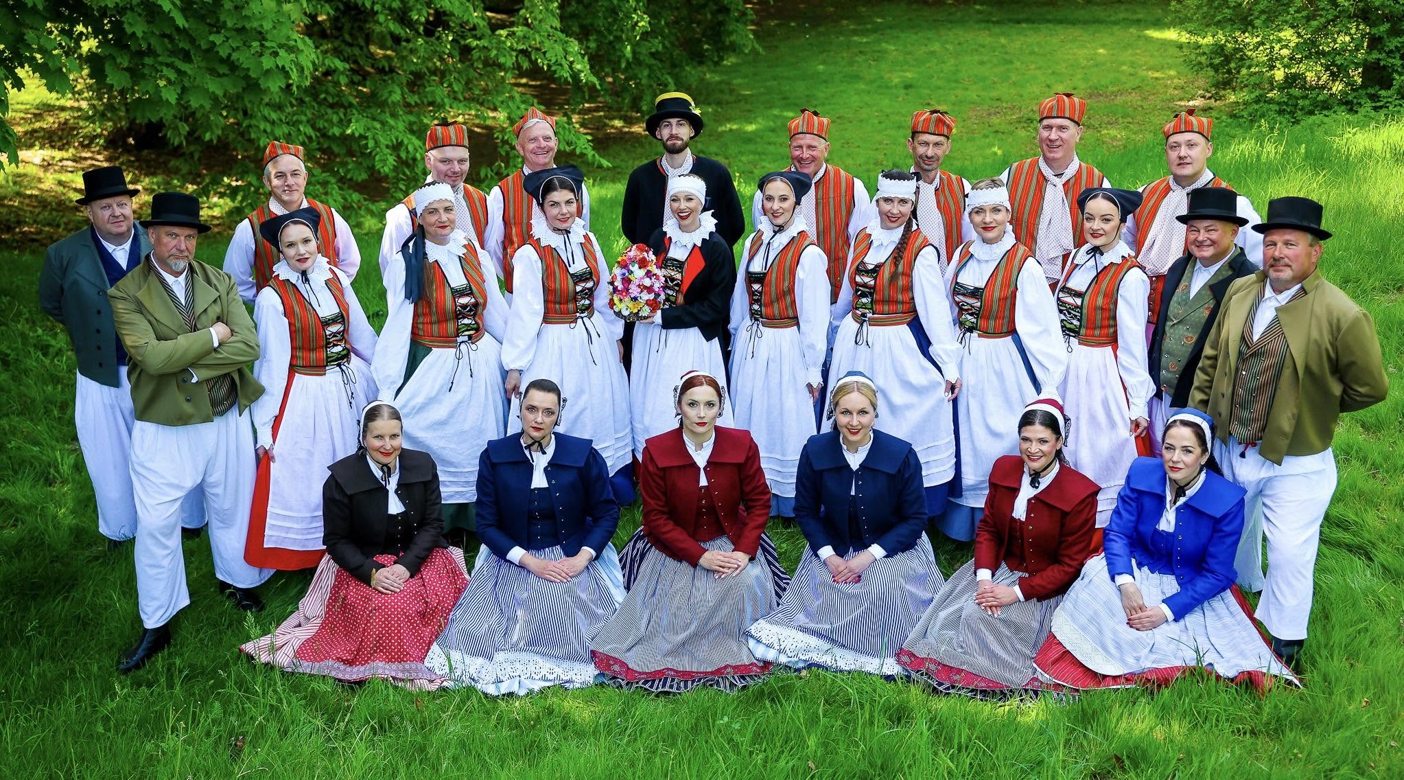 Zespół Krąg w tradycyjnych strojach ludowych na wspólnym zdjęciu w plenerze
